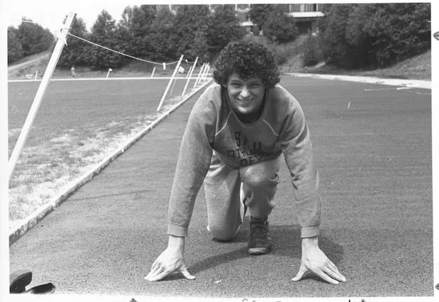 Terry Fox in a starting pose, training outdoors during his university years